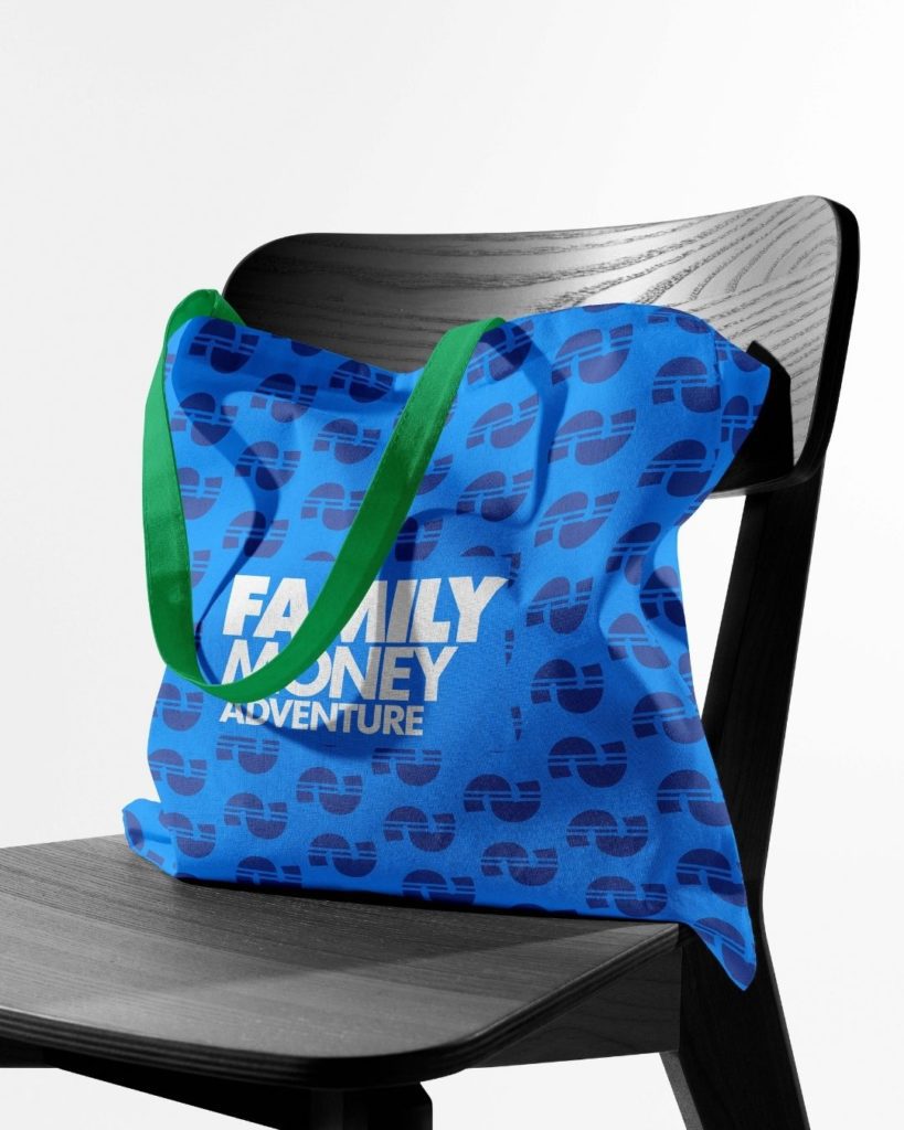 A bag sitting on a chair that has a pattern on it with a logo that reads "Family Money Adventure"