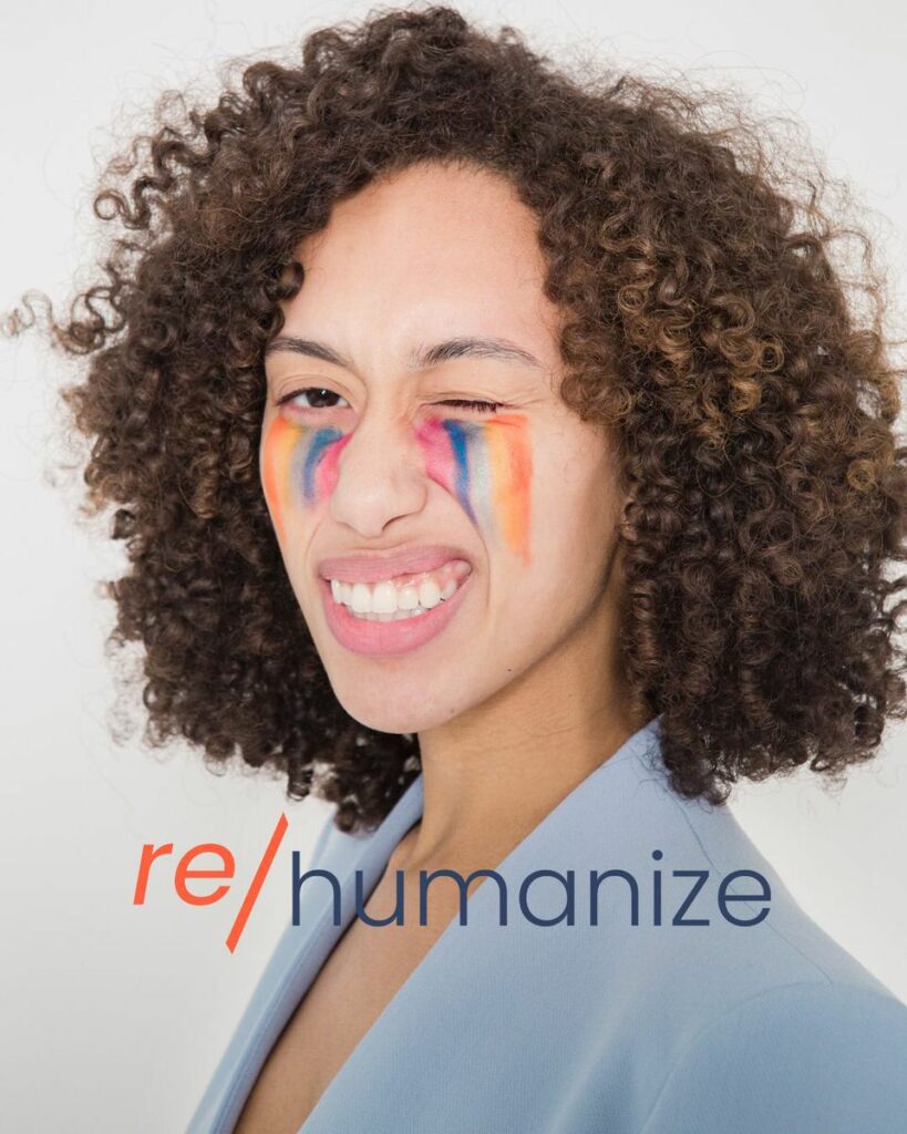 Image of a person with rainbow paint on their cheeks. At the bottom of the image are the words "re/humanize"