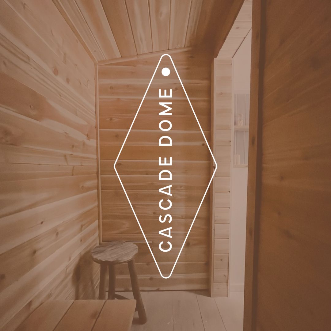 Inside of a wooden sauna with a logo across the middle that reads "Cascade Dome".