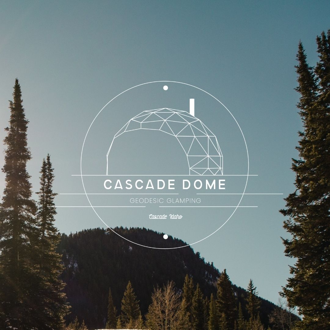 Image of a forest in the mountains with a circular logo in the middle for "Cascade Dome. Geodesic Glamping. Cascade, Idaho".