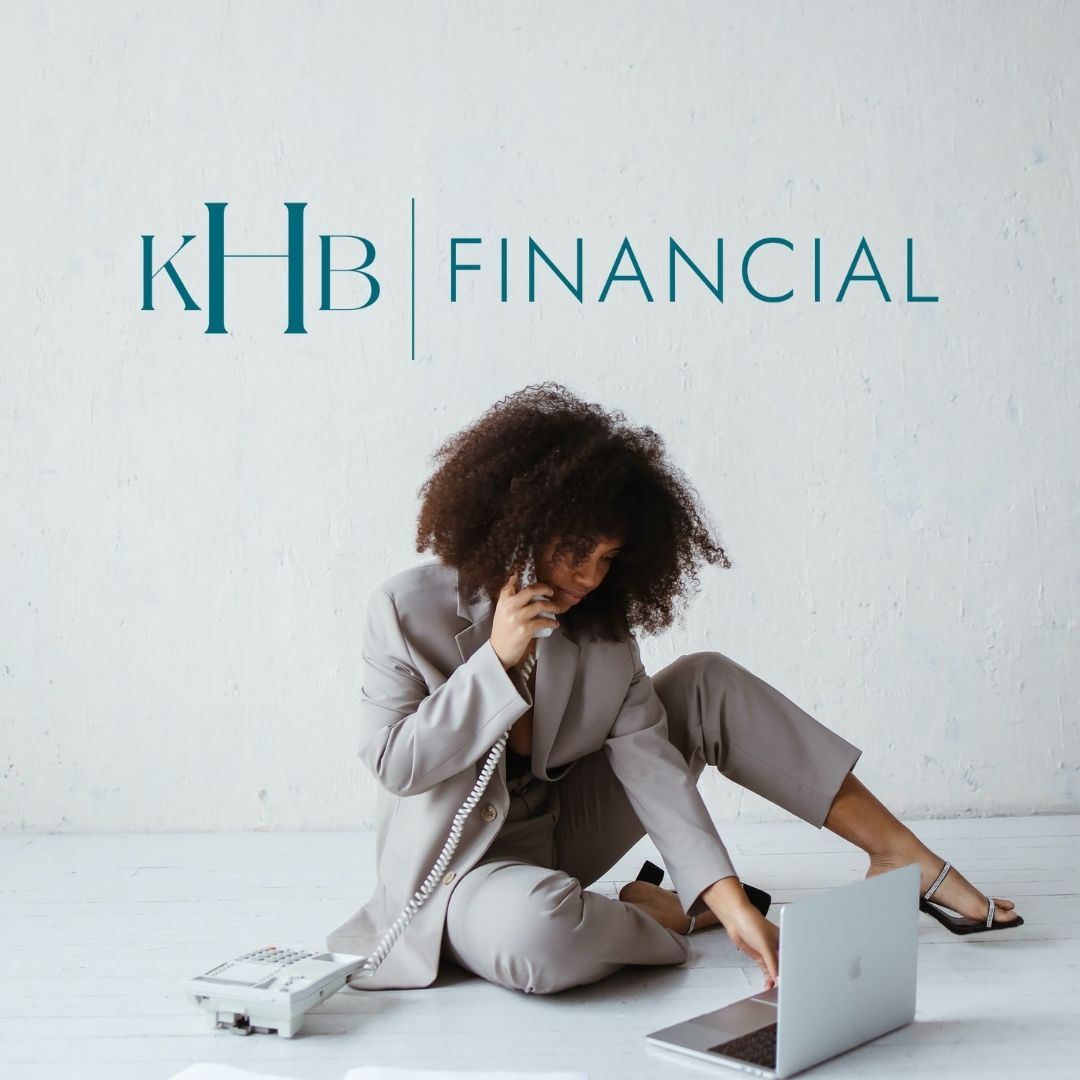 Person sitting on the floor typing on a computer while they are on the phone. Above her is a logo that says "KHB | Financial".