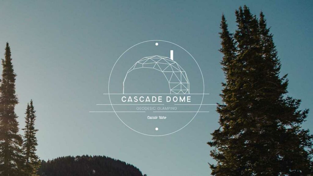 large trees with blue skies behind them and a logo in the center that says "Cascade Dome. Geodesic Glamping. Cascade, Idaho"
