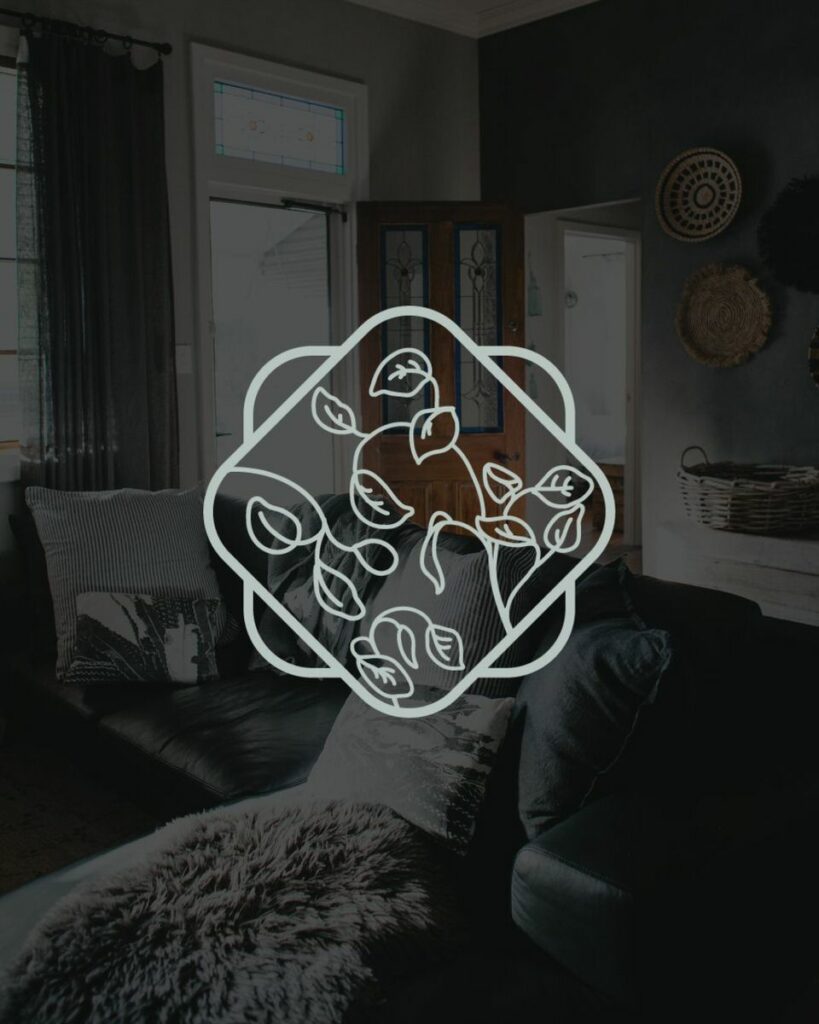 Image of a couch in a small room with a dark overlay and a light blue, floral icon in the middle 