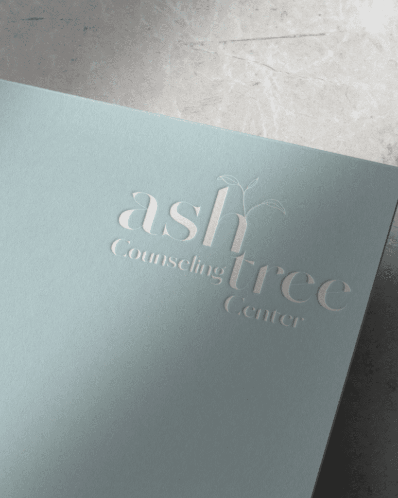 close up view of the corner of a piece of paper with a logo stamped on it that says "Ash Tree Counseling Center"