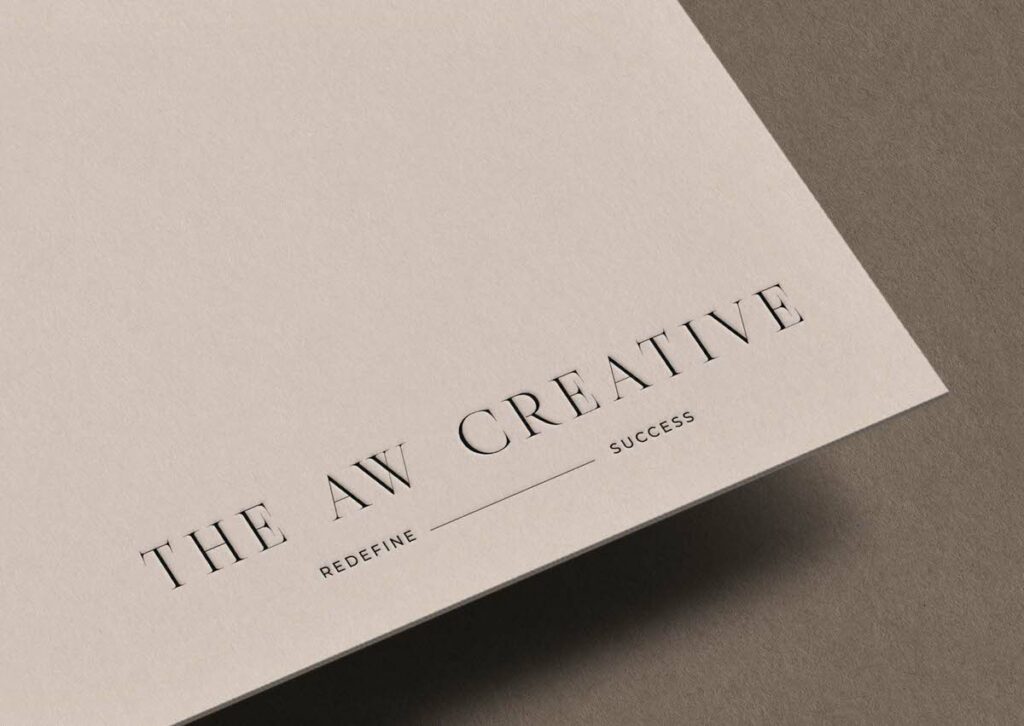 close up of the bottom corner of a piece of paper with a logo on it that says "The AW Creative redefine success"