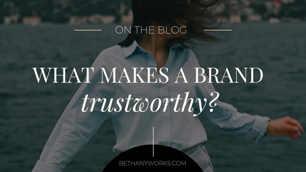 Image of a woman swinging her hair with a dark overlay on the image. On top is text that reads "On the blog. What makes a brand trustworthy?"