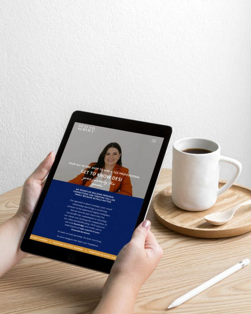 A person holding a tablet vertically with the "Desi Tax Service" website on the screen, featuring a portrait of a smiling woman with a headline about hiring a tax professional.